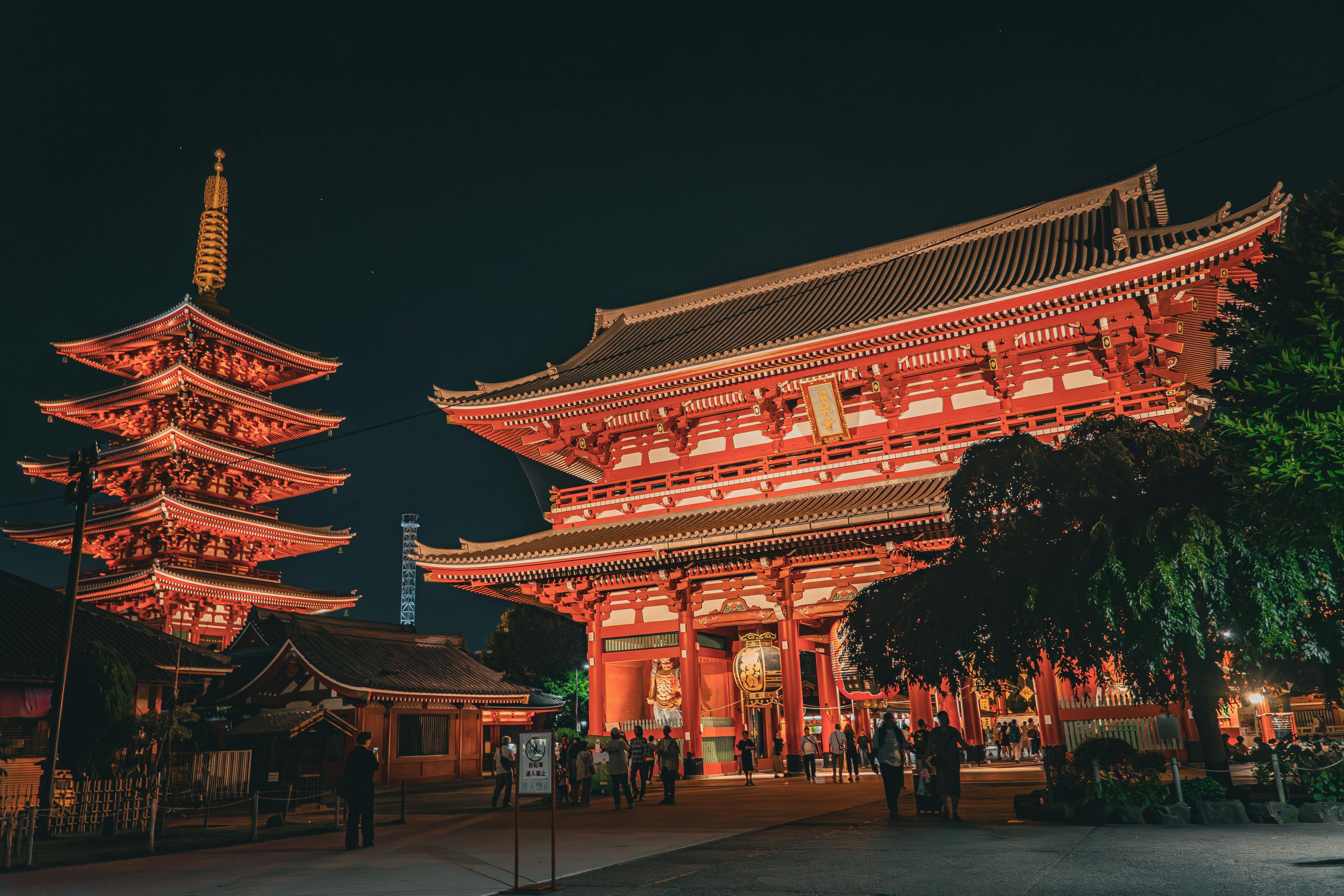 A brightly lit pagoda at night, showcasing traditional Asian architecture against a dark sky
