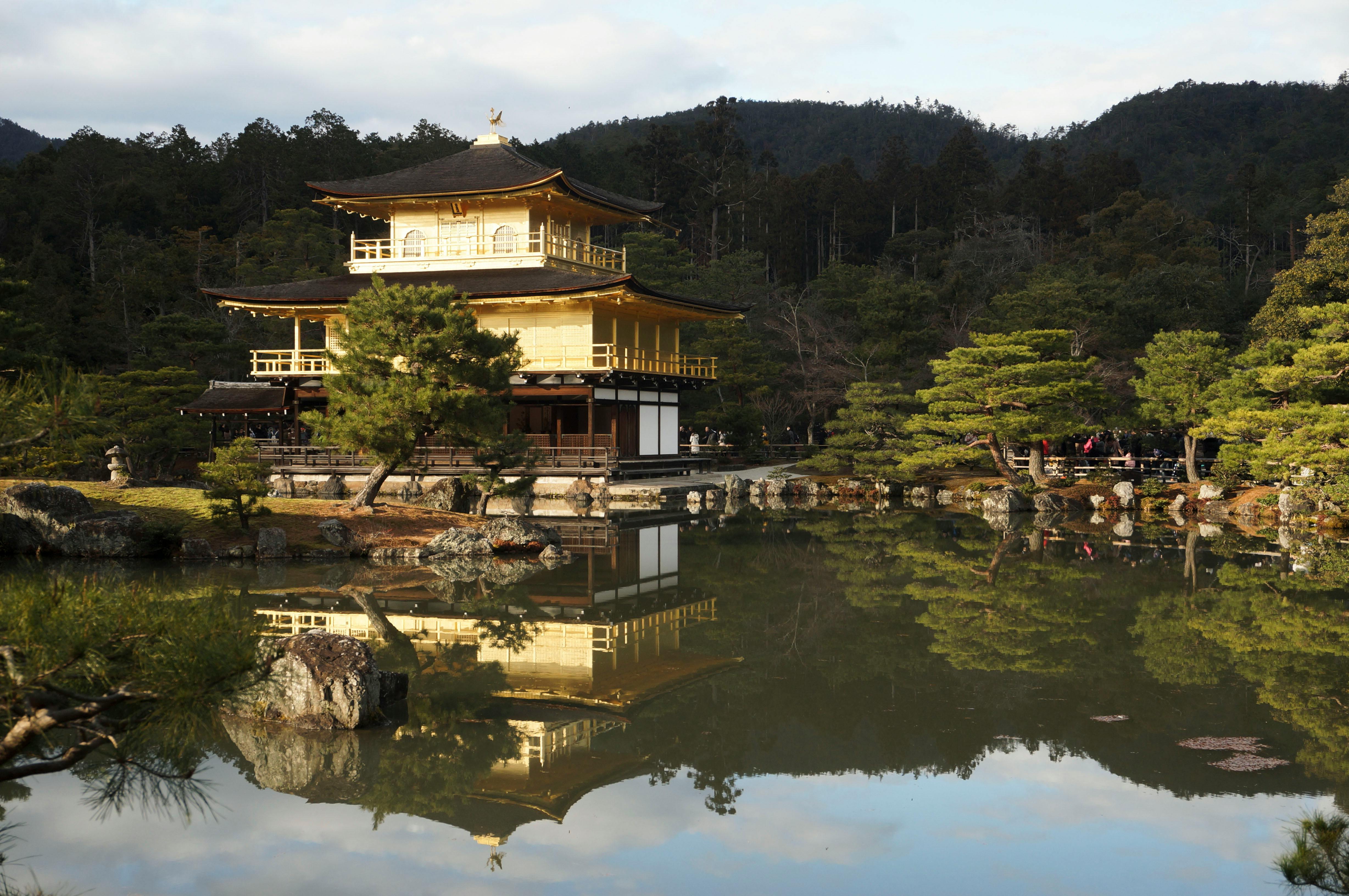  Kinkaku-ji, the Golden Pavilion, surrounded by lush greenery in Kyoto, Japan, reflecting in a serene pond