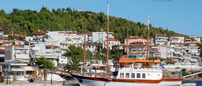 Mykonos harbor with white houses, boats, and hillside backdrop